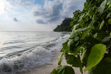 Deniz dalgaları parlak gündoğumu ile dramatik gökyüzü sabah