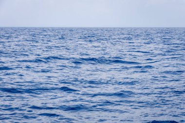 Huzurlu su okyanus yüzeyinde gündüz dalgalanır.