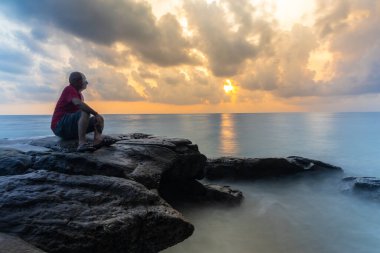 Tecrit edilmiş yaşlı adam illüzyonu etkisi uzun süre bulanıklık yaratır deniz ufkunda dramatik gündoğumu gökyüzü