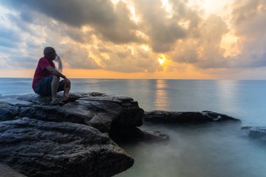 isolated old man holding mobile illusion effect long exposure blur with sunrise sky and sea horizon clipart