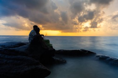 İzole edilmiş çift illüzyonu, deniz ufkunda dramatik gündoğumu gökyüzü ile uzun süre bulanıklık yaratıyor.
