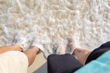 Andaman ve Nicobar Adaları 'ndaki Havelock Adası' ndaki Radhanagar Sahili 'nde sabah görüntüsünde beyaz kumsalda dalgalanan deniz dalgalarıyla evli çiftler görülüyor..