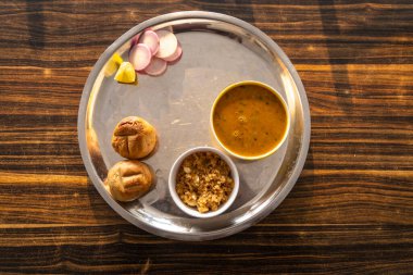 Çelik tabakta servis edilen geleneksel Hint yemeği dallı bati churma Rajasthan 'da çekildi. Dal baati churma Hindistan 'ın Rajasthan eyaletinde popüler bir yemektir..