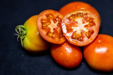 Taze kırmızı domates dilimlenmiş siyah arka planda yakın çekim stüdyosu.