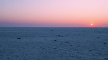 Gün batımı ufku beyaz tuz düzlükleriyle çöl ve dramatik turuncu gökyüzü şafak vakti dramatik turuncu gündoğumu gökyüzü çöl dhordo kutch beyaz rann gujrat Hindistan 'da çekilir..
