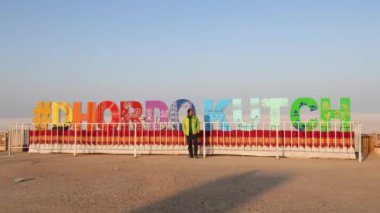 Düz açılı videodan parlak mavi gökyüzüyle yürüyen genç adam Dhordo Kutch White Rann Gujrat Hindistan 'da çekiliyor..