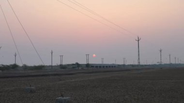 Kuru tarlalar, güneş doğarken parlak turuncu gökyüzü.