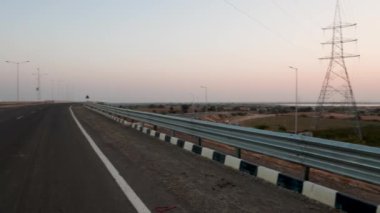 Günbatımı manzaralı asfalt otoyol ve akşamları turuncu gökyüzü