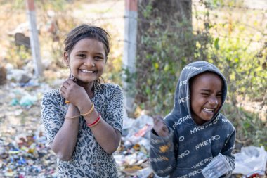 young poor garbage collecting kids with cute smiling facial expression at outdoor at day clipart