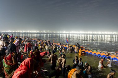 spiritual gathering of devotees at triveni sangam at mahakumbh festival at night image is taken at mahakumbh mela prayagraj uttar pradesh india on Feb 17 2025. clipart