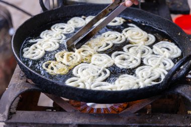 Geleneksel Hint Jalebi 'si yerel tatlı tezgahta kızarıyor.
