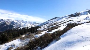 Taze kar ve açık mavi gökyüzü ile kaplı kar örtüsü sıradağları sabah videosu alınır Chopta Tungnath Himalayas dağı Chandrashila yürüyüşü uttarakhand.