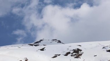 Kar tepesi zirvesi, parlak mavi gökyüzü arkaplanı ile sabah