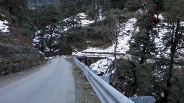 İzole edilmiş asfalt yolda, karlı dağda, düz açıyla.