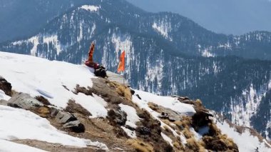 Sabah tapınakta sallanan kutsal Hindu bayrağıyla kar tepesi zirvesi.