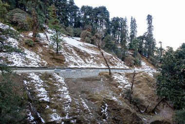 Düz açılı görüntüler Chopta uttarakhand Hindistan 'da karlı dağda izole edilmiş asfalt yolda çekilmektedir..