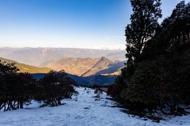 Chandrashila trek tungnath chopta uttarakhand Hindistan 'da parlak mavi gökyüzü görüntüsüne sahip katmanlı dağların el değmemiş görüntüsü çekilmiştir..