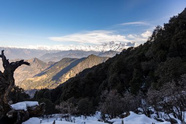 Parlak mavi gökyüzü olan katmanlı dağların el değmemiş manzarası.
