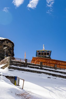 Parlak mavi gökyüzü altındaki donmuş dağ tepelerindeki görkemli hindu tapınağı Chandrashila trek tungnath mahadev tapınağı chopta uttarakhand Hindistan 'da çekilmiştir..