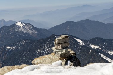 Kar tepesi zirvesindeki kutsal taş soluk kesici manzara arkaplanına sahip sabah görüntüsü Chandrashila yürüyüşü tungnath chopta uttarakhand Hindistan 'da çekilmiştir..