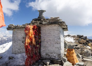 Güneşin doğuşunda kar tepesinde kutsal bayrakları olan kutsal tapınak Chandrashila Zirvesi tungnath Chopta uttarakhand Hindistan 'da çekilmiştir..