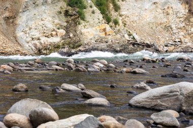 Düz açılı küçük deresi olan kayalık nehir yatağı