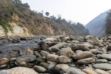 Düz açılı küçük deresi olan kayalık nehir yatağı