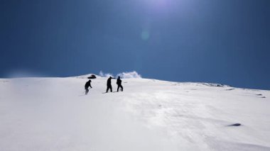 Öğleden sonra, karla kaplı dağ zirvesine tırmanan bir grup yürüyüşçü Chopta Tungnath Himalayas dağında, Chandrashila dağında, uttarakhand Hindistan 'da çekilir..