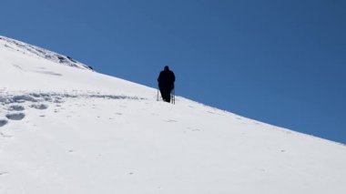 Öğleden sonra, karla kaplı dağ zirvesine tırmanan bir grup yürüyüşçü Chopta Tungnath Himalayas dağında, Chandrashila dağında, uttarakhand Hindistan 'da çekilir..