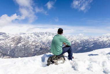 Öğleden sonra, parlak mavi gökyüzü ile zirveden karlı dağ zirvelerine hayran olan yalnız gezgin Chopta Tungnath Himalayas Dağı Chandrashila yürüyüşü uttarakhand Hindistan 'da çekilmiştir..