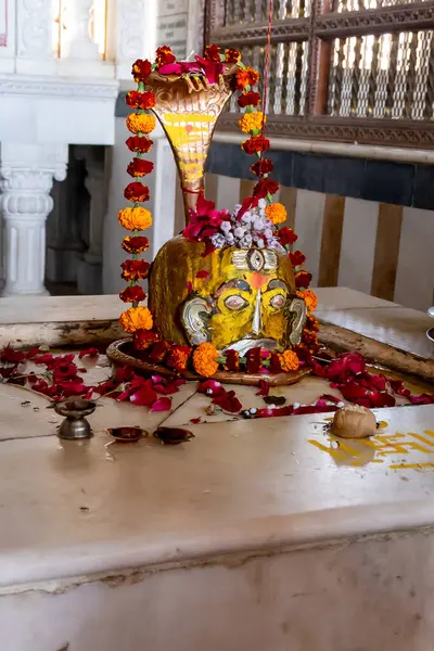 Tapınakta sunulan çiçeklerle süslenmiş Hindu tanrısı Shivalinga.