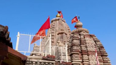 Kutsal bayrak sallayan antik Hindu tapınağı ve sabah çekilen açık mavi gökyüzü videosu Osiyan Sacchiyay Mata Tapınağı, jodhpur, Rajasthan, Hindistan 'da çekilmiştir..