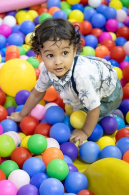 Küçük Hintli çocuk oyun sahasında mutlu bir şekilde oynuyor
