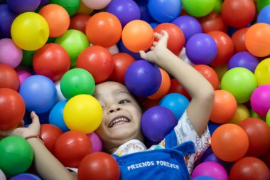 Çocuklar oyun oynarken gülümseyen sevimli erkek bebek.