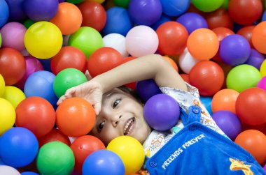 Çocuklar oyun oynarken gülümseyen sevimli erkek bebek.