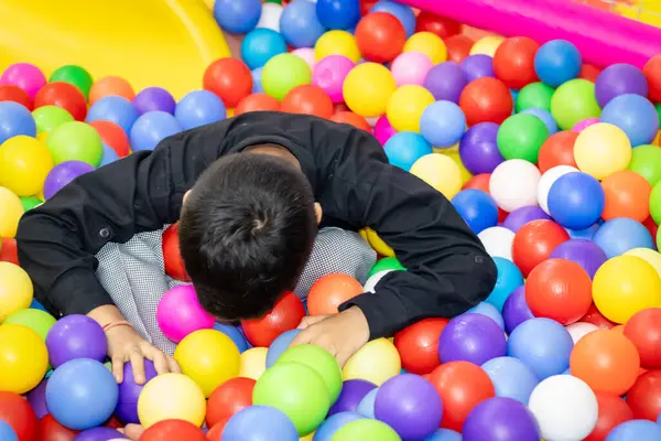 Kızılderili çocuk oyun sahasında renkli baloda uyuyor.