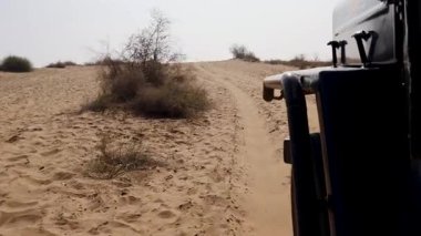 San Kum tepeleri safarisi ve çöllerde gün içinde otomobille farklı açılardan indirme Rajasthan, Hindistan 'da çekiliyor..