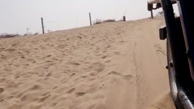 San Kum tepeleri safarisi ve çöllerde gün içinde otomobille farklı açılardan indirme Rajasthan, Hindistan 'da çekiliyor..