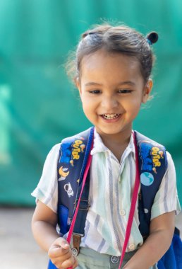 Güneşli bir günde okulun ilk günü için yalvaran sevimli Hintli çocuk ifadesi.
