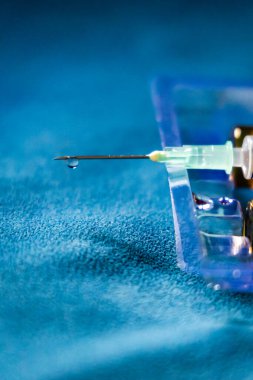 Sıvı ilaç damlacıklarıyla dolu şırınga kullanıma hazır ve kapalı alanda boş ilaç şişesi