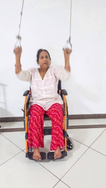 Tekerlekli sandalyedeki felçli hasta hareket kabiliyetini düzeltiyor hareket bulanıklığı ile fizyoterapi yapıyor.