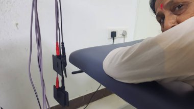 Hasta içeride elektrot ile fizyoterapi seansı için Plinth 'te yatıyor.