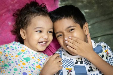 Şirin Hintli erkek bebek evde kardeşiyle farklı ifadeler sergiliyor.