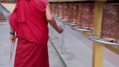 Kutsal keşişler kutsal Budist dua çemberi ya da manastırda dönen manikür çarkları arasında geziniyorlar.