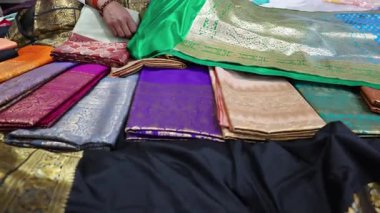 Renkli varanasi ipeği sarileri kapalı mağazada sergileniyor.