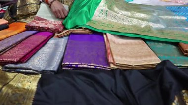 Renkli varanasi ipeği sarileri kapalı mağazada sergileniyor.