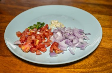 Taze doğranmış çiğ sebzeli soğan biberli domates ve seramik tabakta sarımsak.
