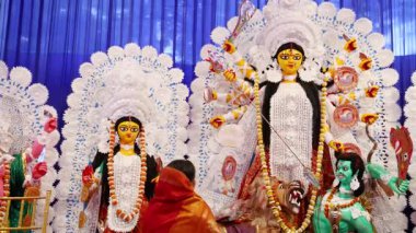 Tanrıça Durga heykeli ve duacı gün ışığında dualarını sunuyor.