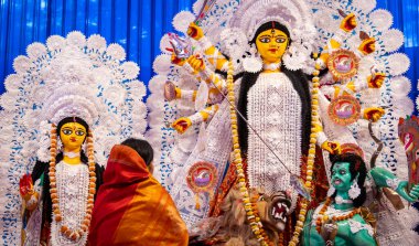 Tanrıça Durga heykeli ve duacı gün ışığında dualarını sunuyor.