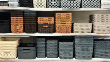 Örgü ve plastik depolama sepetleri raflarda güzelce sergileniyor. Ev düzenleme, ev kullanımı ve azalan alanlar için mükemmel.